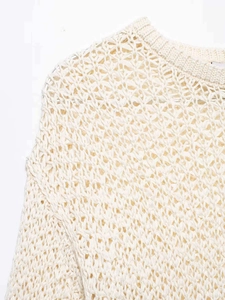 Close-up of the cream crochet knit sweater showing intricate floral hollow-out patterns