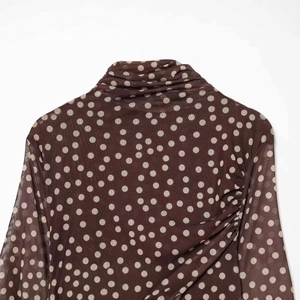Brown polka dot mesh turtleneck top with elegant gathered side details for women