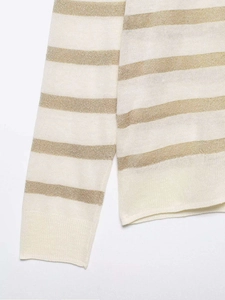 Close-up of metallic gold stripes and fine knit texture on long sleeve sweater