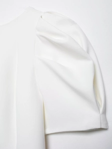 Detail shot of elegant white puff sleeves with pleated shoulder design and crisp fabric