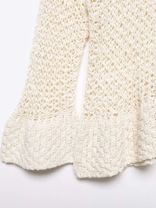 Detailed macro view of cream crochet knit fabric showing intricate openwork patterns