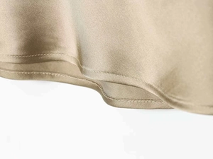 Macro shot of the champagne satin hem featuring premium double-stitched reinforced edges