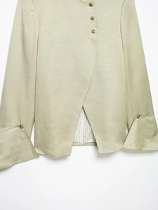 Detail of light green blazer with retro metal buttons and striped lining on cuffs