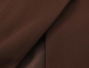 Detail of dark brown suit fabric showing refined texture and high-quality inner lining