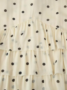 Détail d'une robe à pois avec des volants étagés et un tissu en mousseline léger