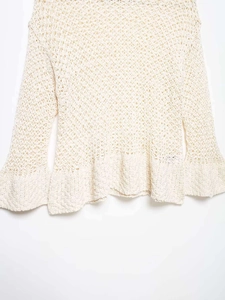 Detailed view of cream openwork crochet knit sweater with bell sleeves and hollow texture