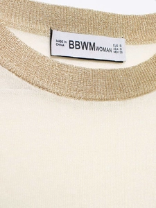 Macro detail of knit sweater neckline with metallic gold thread and brand label S