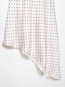 Vue détaillée de la jupe en satin à pois avec un ourlet asymétrique élégant