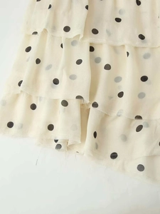 Détail de la robe à pois crème à volants avec bords francs et texture de tissu léger