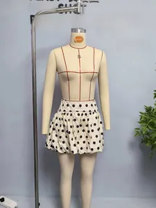Vue détaillée d'une jupe bouffante taille haute à pois noirs sur tissu beige élégant