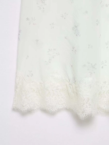 Close-up of floral print nylon skirt with delicate white lace trim and eyelash edges