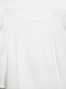 Detailed view of the elegant white puffed sleeve and minimalist round neckline