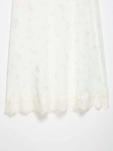Detail of floral nylon skirt showing light purple prints and delicate lace trim hemline