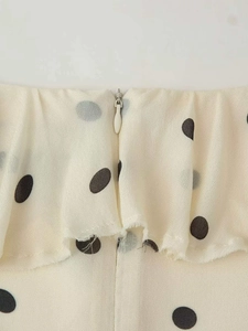 Détail de la robe à pois crème avec fermeture éclair invisible et volants élégants