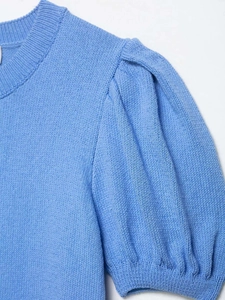 Détail du col rond et des manches bouffantes sur ce cardigan en tricot bleu ciel