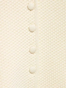 Détail du cardigan en maille crème avec texture nid d'abeille et boutons tissus