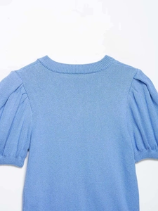 Texture détaillée du haut en maille bleu clair avec col rond et manches bouffantes