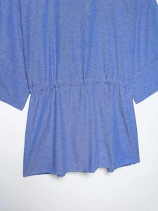Dettaglio ravvicinato della vita elastica con coulisse sulla camicia blu estiva