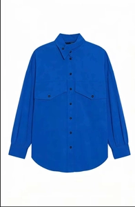 Detail of bright blue long-sleeve shirt with large chest pockets and button-down front