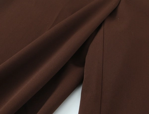 Detailed macro shot of dark brown suit fabric texture with precise hemline stitching