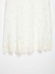 Detail of elegant off-white floral skirt featuring delicate lace hem and refined stitching