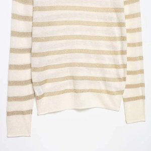 Chic long sleeve knit sweater featuring metallic gold and off-white horizontal stripes