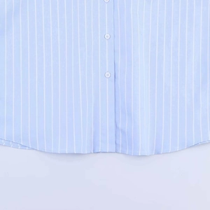 Detail of blue striped shirt showing white buttons and curved hem with neat stitching