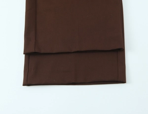 Detailed view of dark brown trouser hem with straight stitching and twill fabric texture