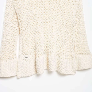 Off-white crochet knit long sleeve top with intricate openwork detailing and flared hem