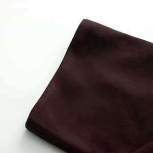 Detailed macro view of dark brown knitted fabric texture for a boat neck mini dress