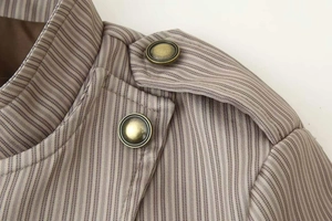 Détail du col montant avec pattes d'épaule et boutons vintage sur une veste à rayures