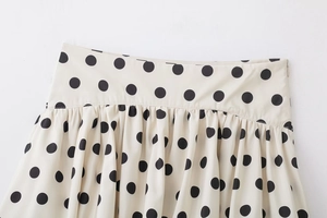 Détail d'une jupe-culotte plissée à pois noirs avec taille haute et fermeture éclair invisible