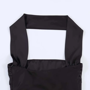 Dettaglio dello scollo a foulard in raso nero e della texture del tessuto dell'abito estivo