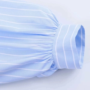 Detailed macro shot of puffed sleeve cuffs on a blue and white striped cotton shirt