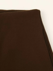 Macro shot of dark brown wool fabric texture with fine plush finish on cropped casual pants