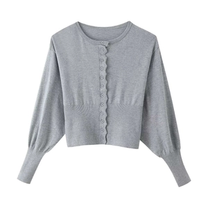 Close-up of light grey knitted cardigan with scalloped edges and single-breasted buttons