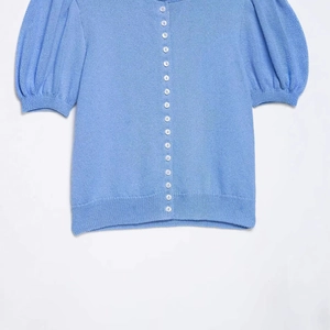 Gilet en maille bleu ciel à manches courtes bouffantes et boutons blancs