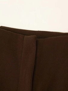Macro shot of dark brown wool fabric texture with precise stitching on waist area