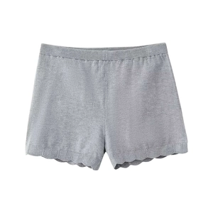 Detail of grey knitted shorts with a ruffled scalloped hem and elastic ribbed waistband