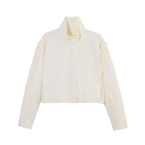 Detalle de chaqueta crema con cuello alto, tapeta oculta y puños con abertura lateral