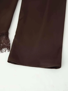 Dettaglio di tessuto marrone cioccolato con bordo in pizzo e finitura satinata