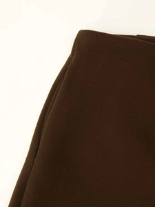 Close-up of deep brown wool fabric showing fine texture and neat stitching on casual pants