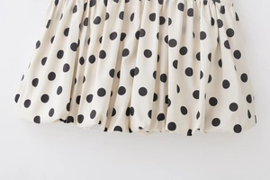 Détail du tissu blanc à pois du short-jupe avec ourlet plissé bouffant et texture rétro