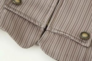 Détail de la veste marron à rayures avec boutons métalliques et ourlet arrondi fini