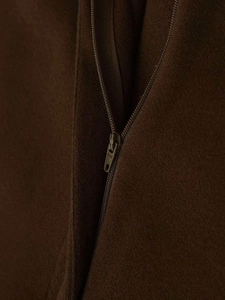 Macro shot of dark brown wool fabric texture with matching zipper detail on casual pants