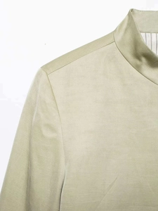 Close-up of khaki stand-collar shirt detailing fine fabric texture and striped lining