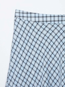 Détail de la jupe asymétrique à carreaux avec motif tissé bleu clair et noir