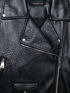 Close-up of black pebble grain faux leather biker jacket with silver metallic zipper details