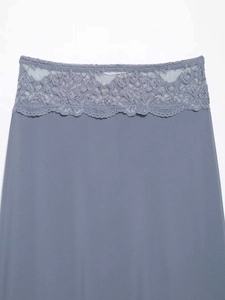 Close-up of grey floral lace trim on a grey-blue high-waisted skirt with fine texture