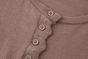 Detailed macro view of the knitted cardigan with neat button placket and matte buttons
